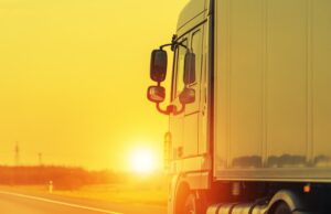 Road Shipping by Semi Truck. Heavy Load Long Haul Euro Transportation Theme. Sunset on the Highway.